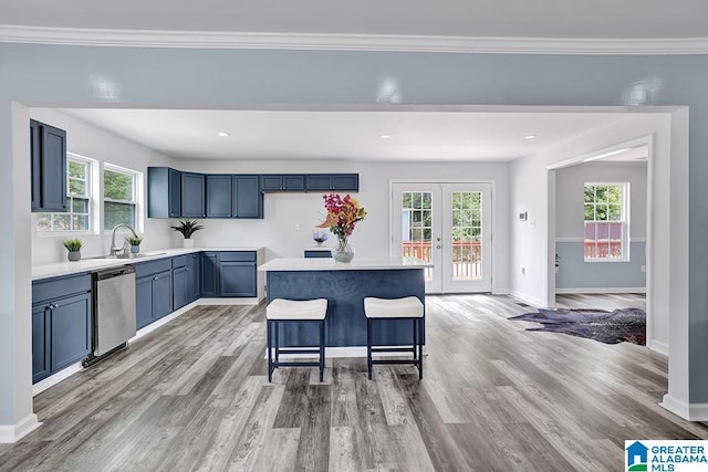 kitchen with a center island, light hardwood / wood-style flooring, stainless steel dishwasher, and a healthy amount of sunlight