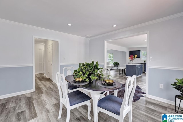 dining area featuring crown molding and light wood-type flooring