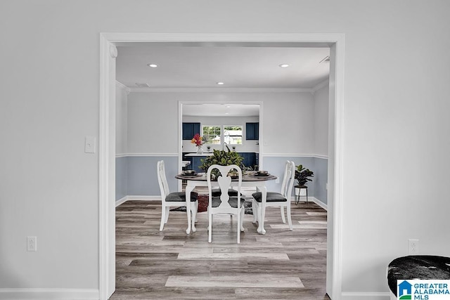 dining room with light wood-type flooring and ornamental molding