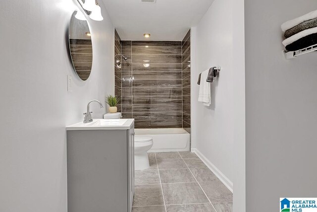 full bathroom with tile patterned floors, vanity, tiled shower / bath combo, and toilet