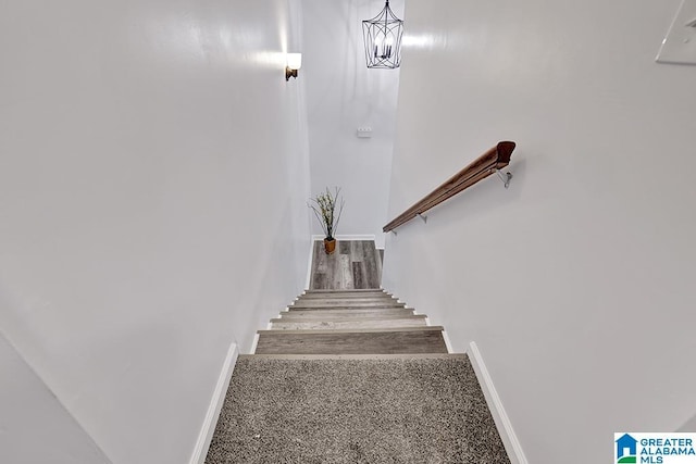 stairs with carpet floors and a chandelier