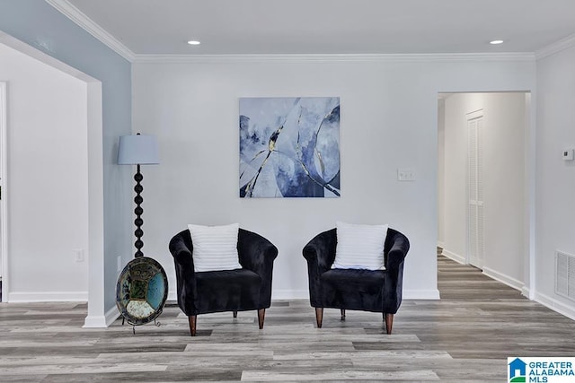 living area featuring light hardwood / wood-style flooring and crown molding