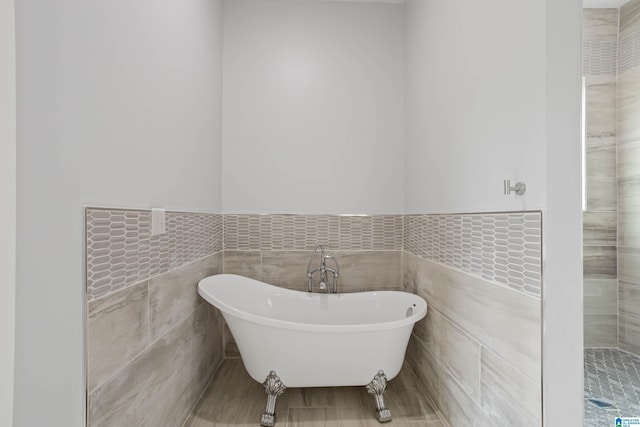 bathroom with a bathing tub and tile walls