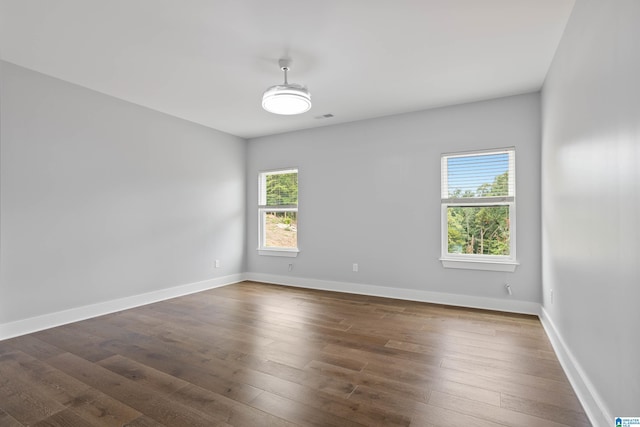 unfurnished room with dark hardwood / wood-style flooring