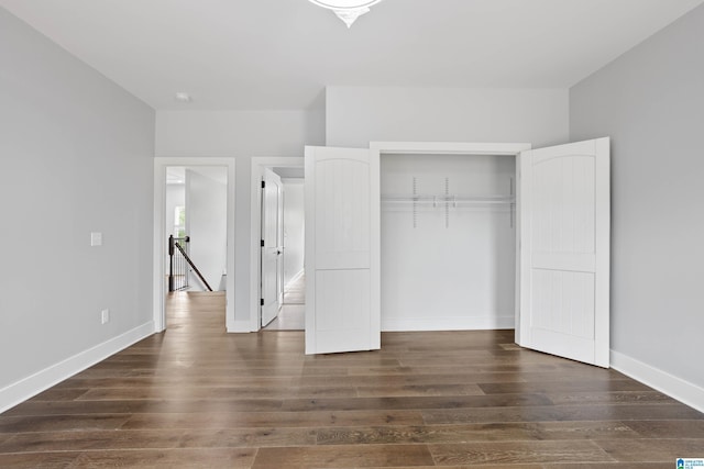 unfurnished bedroom featuring dark hardwood / wood-style flooring and a closet