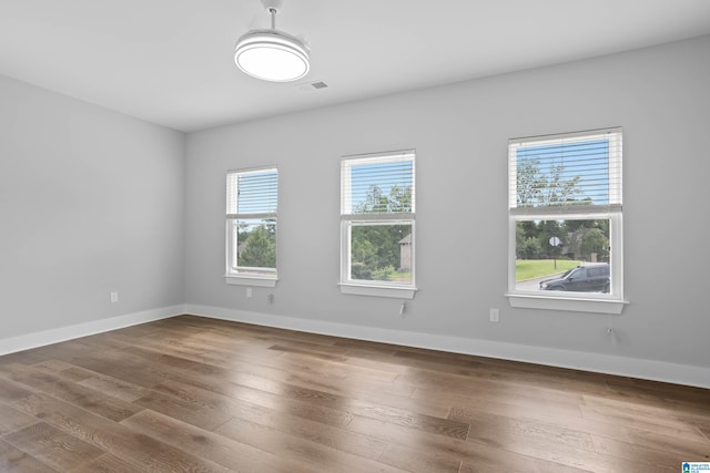 unfurnished room with hardwood / wood-style flooring