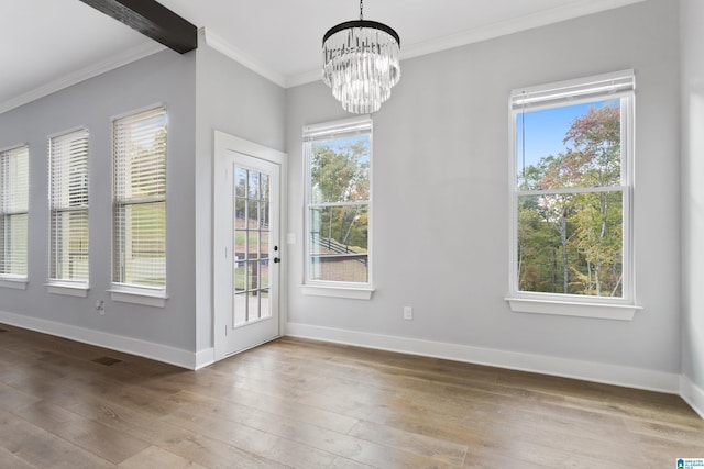 doorway featuring wood-type flooring, ornamental molding, and a notable chandelier