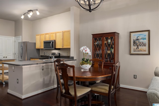 kitchen featuring dark hardwood / wood-style floors, light brown cabinets, stainless steel appliances, an inviting chandelier, and rail lighting