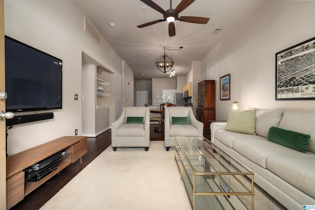 living room featuring hardwood / wood-style floors and ceiling fan with notable chandelier