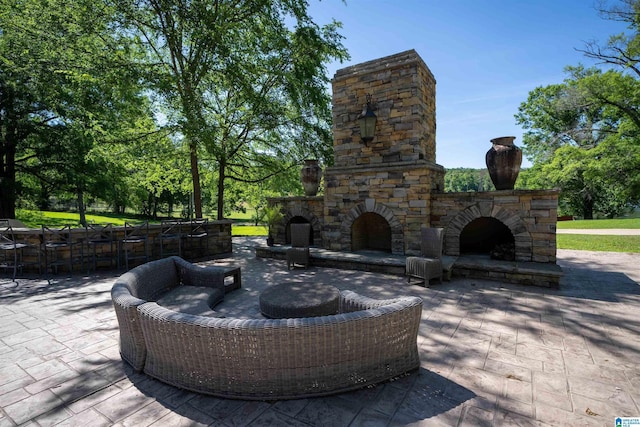 view of patio featuring an outdoor stone fireplace