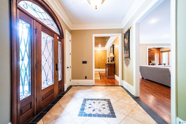 tiled foyer entrance featuring ornamental molding and plenty of natural light