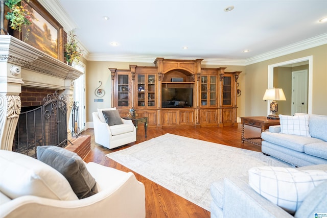 living room featuring wood-type flooring, a brick fireplace, and crown molding