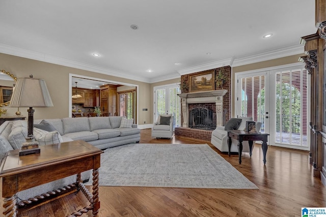 living room with french doors, ornamental molding, a fireplace, and hardwood / wood-style floors