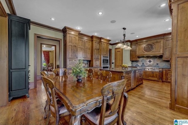 dining area featuring crown molding and light hardwood / wood-style flooring