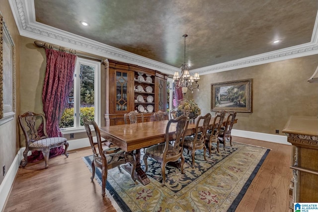 dining area with hardwood / wood-style flooring, ornamental molding, and a notable chandelier