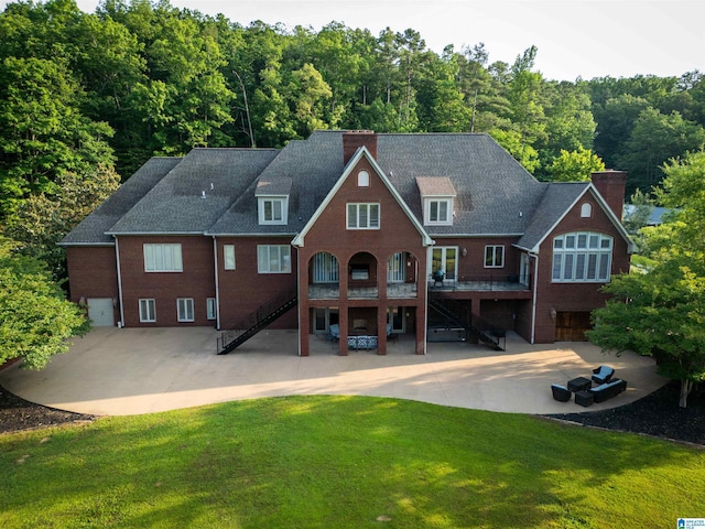 rear view of house with a lawn and a patio