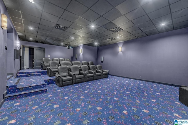 cinema room featuring carpet floors and a drop ceiling