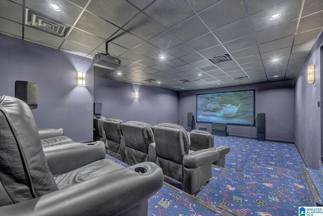 carpeted cinema with a paneled ceiling