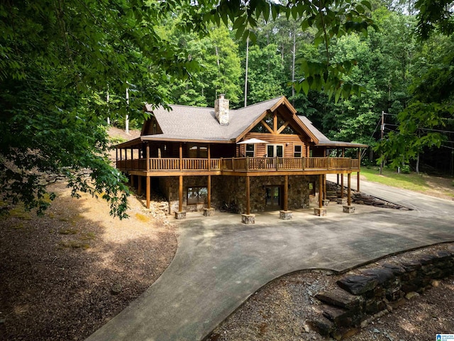 view of front facade featuring a wooden deck and a patio