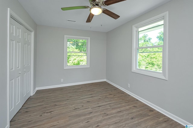 unfurnished bedroom featuring ceiling fan, a closet, and dark wood-type flooring