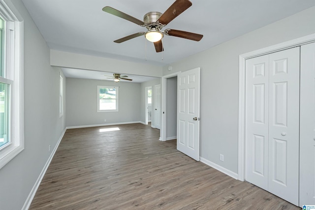 unfurnished bedroom with light wood-type flooring, a closet, and ceiling fan