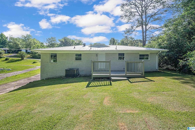 rear view of property featuring a deck, cooling unit, and a lawn