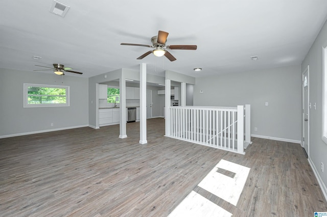 unfurnished living room featuring ceiling fan, light wood-type flooring, and sink