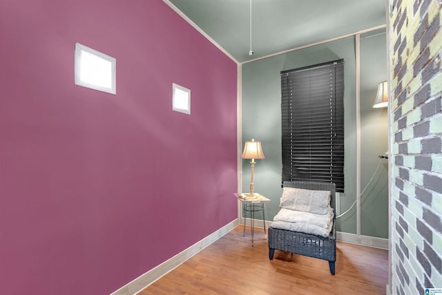 living area featuring wood-type flooring and ornamental molding