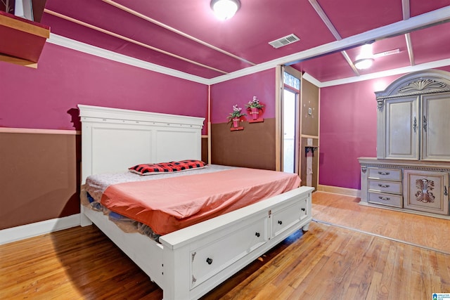 bedroom with wood-type flooring and crown molding