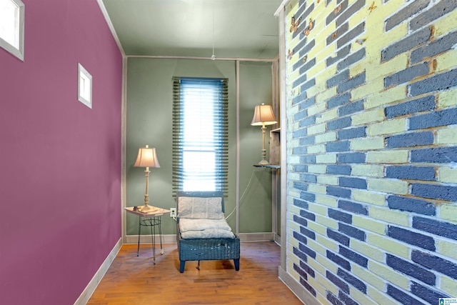 living area with hardwood / wood-style flooring and ornamental molding