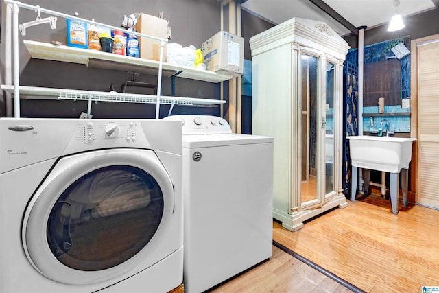 clothes washing area with independent washer and dryer and hardwood / wood-style flooring