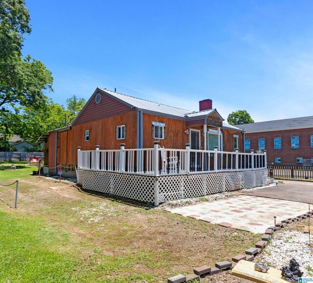 rear view of house featuring a patio area and a wooden deck