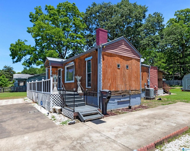 view of front of home featuring cooling unit and a shed