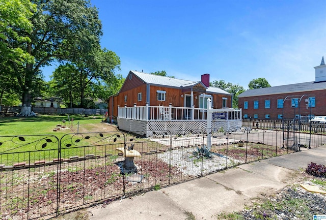 view of front facade with a front lawn and a wooden deck