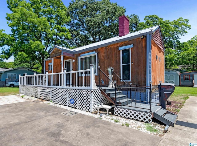 view of front of home featuring covered porch and a storage unit