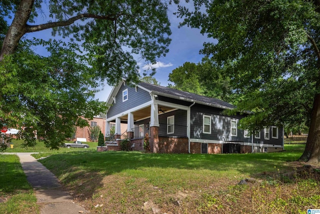 view of home's exterior with a lawn and a porch