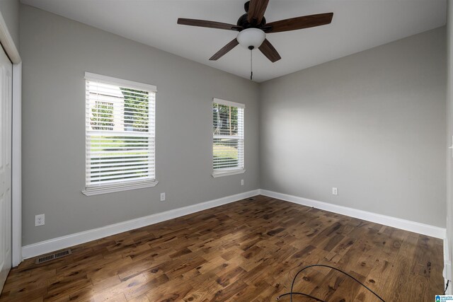 spare room with ceiling fan and dark hardwood / wood-style flooring