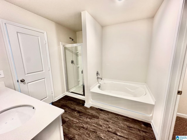 bathroom featuring vanity, wood-type flooring, and shower with separate bathtub