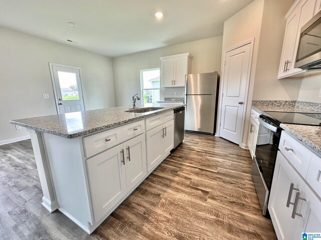 kitchen featuring stainless steel appliances, light hardwood / wood-style floors, a kitchen island with sink, and white cabinetry