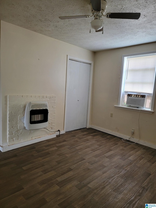 unfurnished living room with a fireplace, heating unit, a textured ceiling, wood finished floors, and baseboards