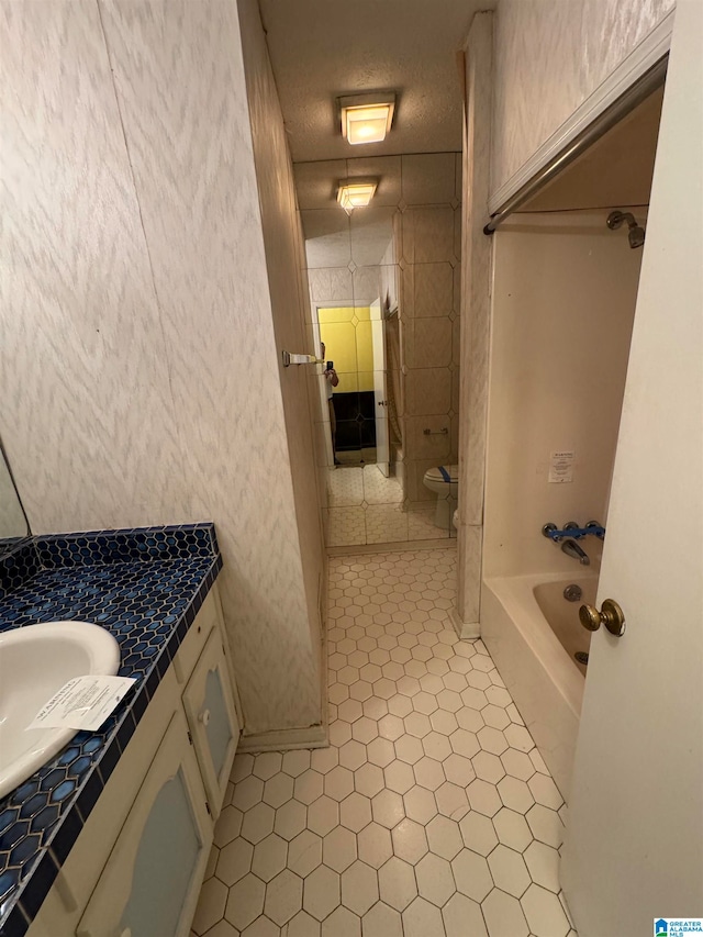 full bathroom featuring tile patterned floors, vanity, a textured ceiling, and toilet