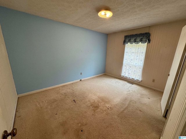 carpeted spare room featuring a textured ceiling