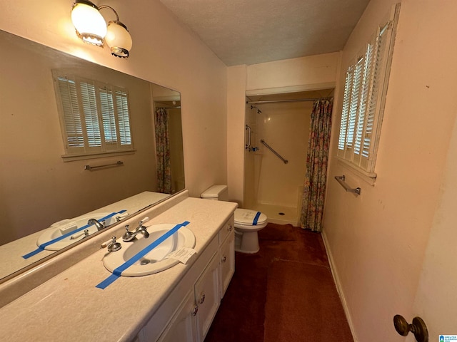 bathroom with vanity, curtained shower, toilet, and a textured ceiling