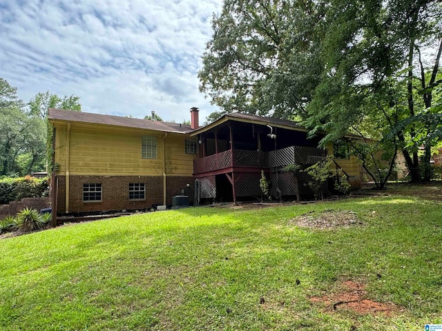 back of house with a lawn, central AC, and a sunroom