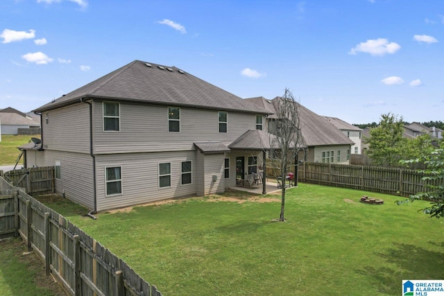 back of house featuring a lawn, a fire pit, and a patio area