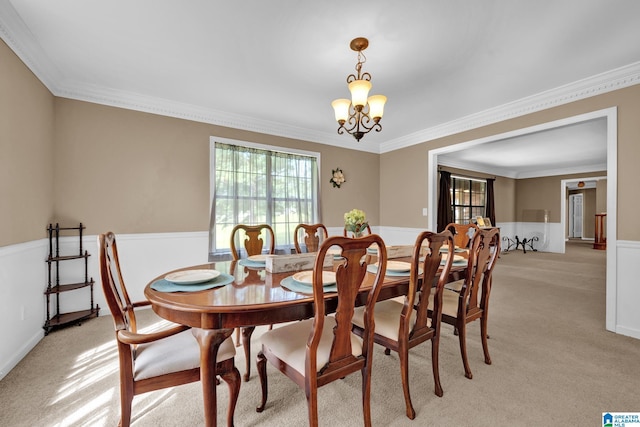 dining space with light carpet, a chandelier, and ornamental molding