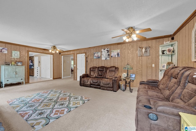 carpeted living room with ceiling fan and ornamental molding