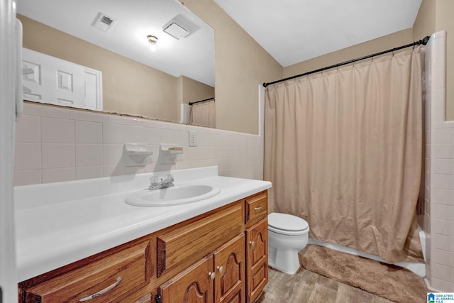 full bathroom with vanity, toilet, shower / bathtub combination with curtain, tile walls, and wood-type flooring