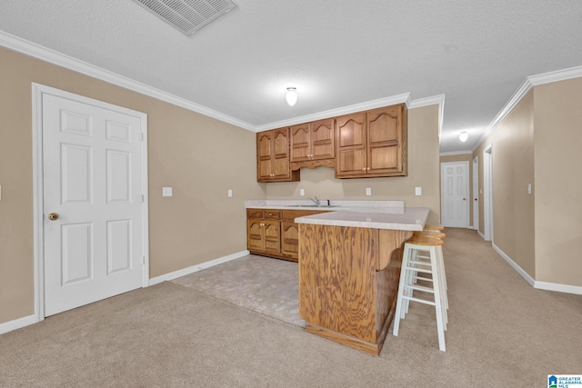 kitchen with kitchen peninsula, sink, a breakfast bar, and ornamental molding