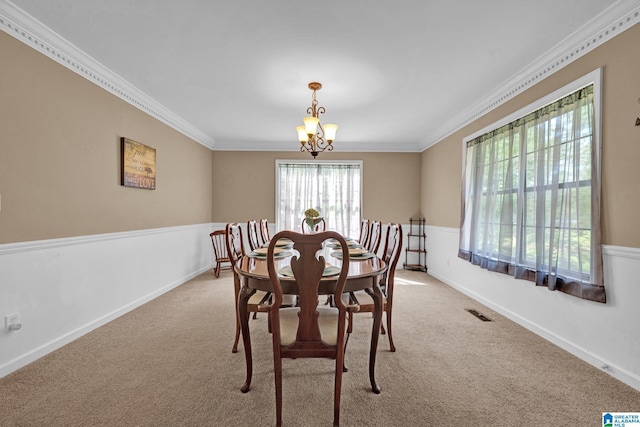 carpeted dining room featuring a chandelier and ornamental molding